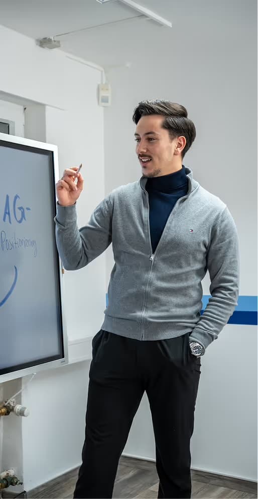 Ein Kollege erklärt Inhalte am Bildschirm